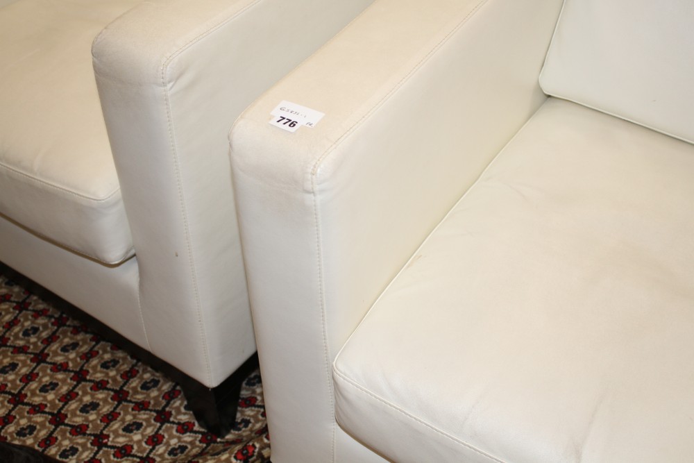 A pair of modern Italian cream leather upholstered armchairs, with ebonised feet, W.80cm D.90cm H.86cm